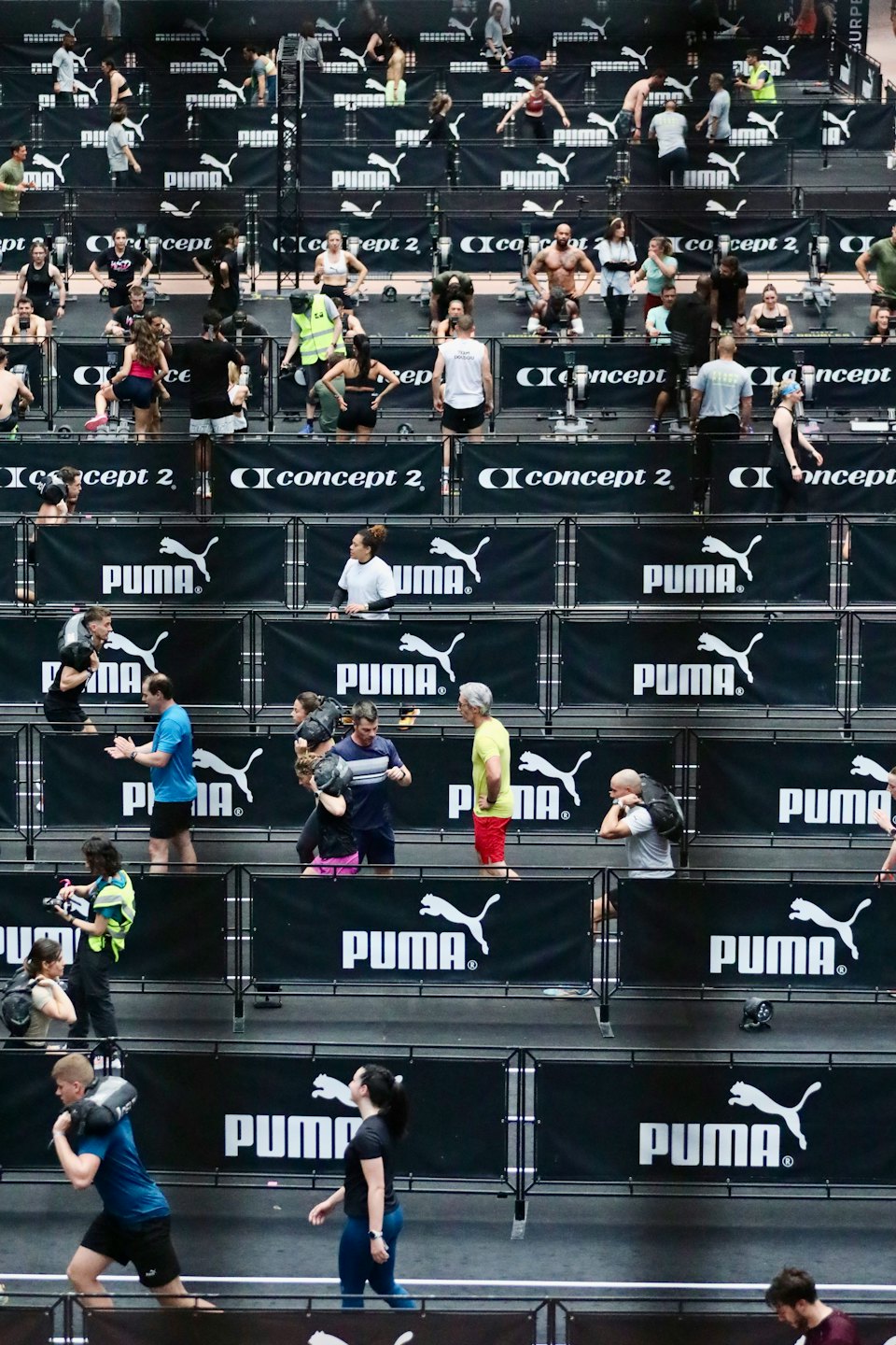 Athletes perform fitness exercises at a large indoor sports competition.