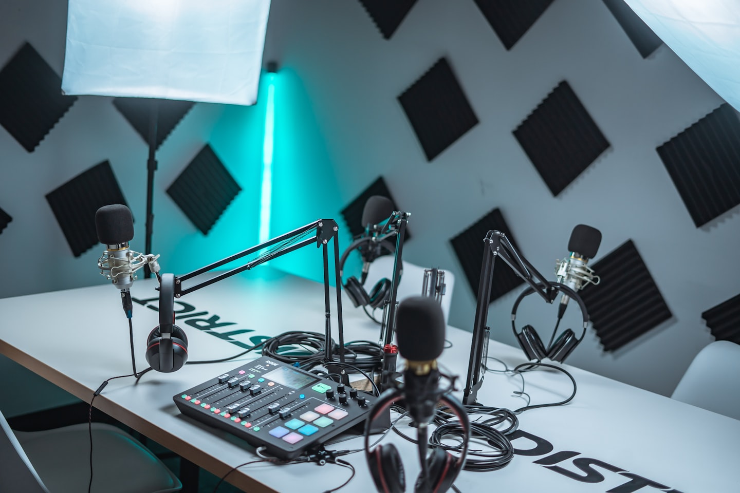 Podcast studio with microphones, headphones, and audio mixer.