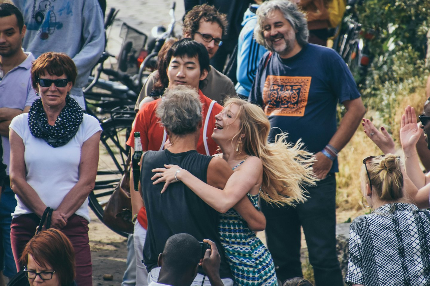 Group of friends laughing and hugging at an outdoor party.